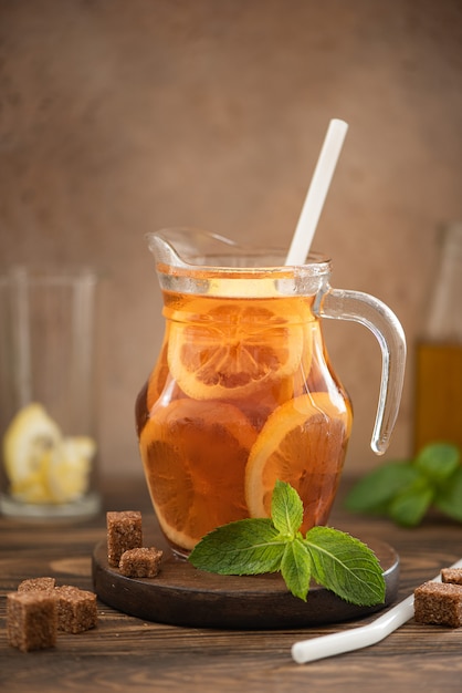 Tè freddo con fettine di limone e menta in una caraffa di vetro