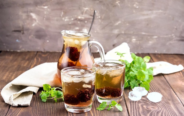 Tè freddo con frutti di bosco e menta fresca in bicchieri Fondo in legno