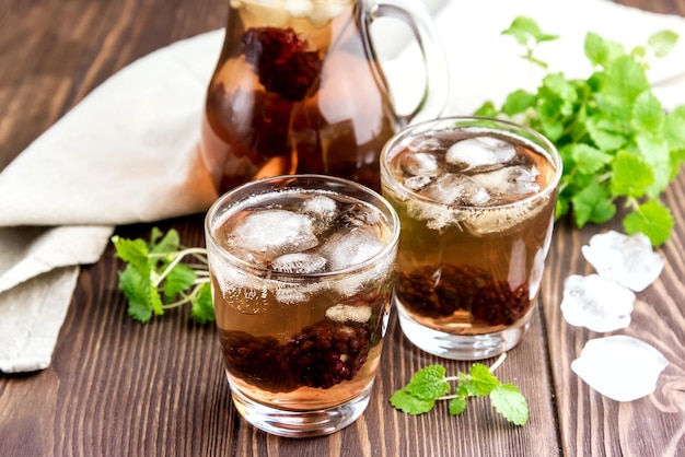 Tè freddo con frutti di bosco e menta fresca in bicchieri Fondo in legno