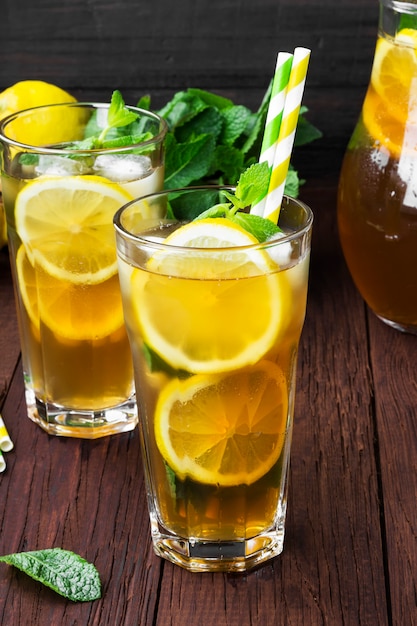 Tè freddo con limone e menta su un fondo di legno