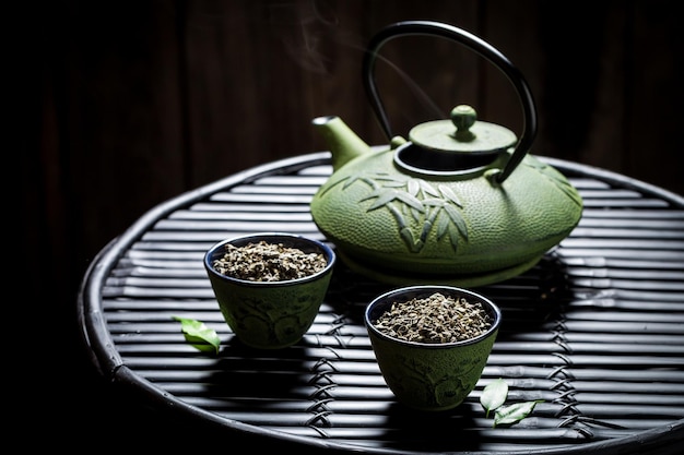 Tè fresco con teiera sul tavolo di bambù nero