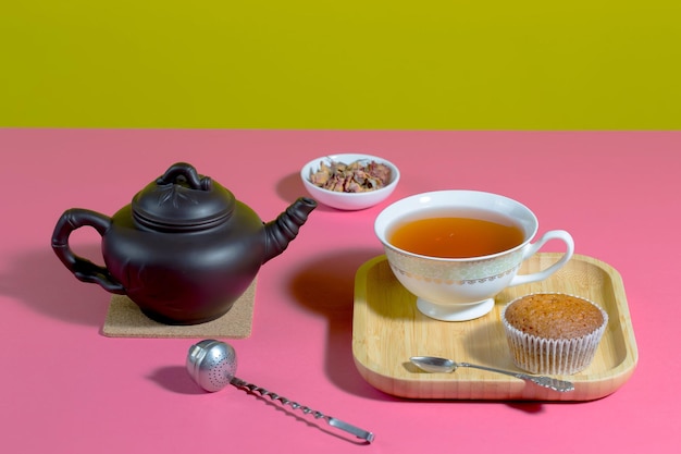 Tè in tazza con dessert su uno sfondo colorato brillante