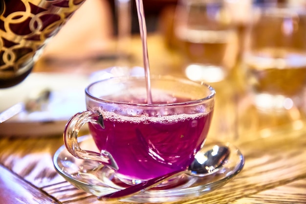 Tè lilla alla frutta con lavanda in una tazza di vetro