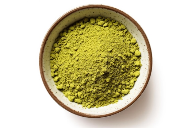 Tè matcha giapponese in polvere verde in una ciotola su sfondo bianco vista dall'alto