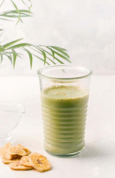 Tè Matcha in un bicchiere su uno sfondo bianco. Colazione salutare