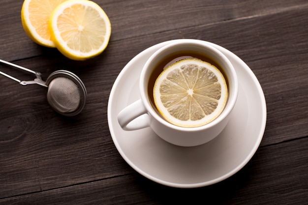 Tè nero con limone su un tavolo di legno