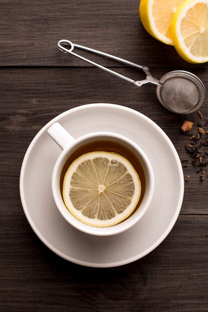 Tè nero con limone su un tavolo di legno