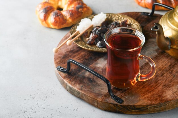 Tè nero turco Tazza di vetro di tè nero turco e bagel tradizionale turco croccante su sfondo grigio tavolo in cemento Concetto di pasticceria per la colazione Bevanda calda tradizionale turca