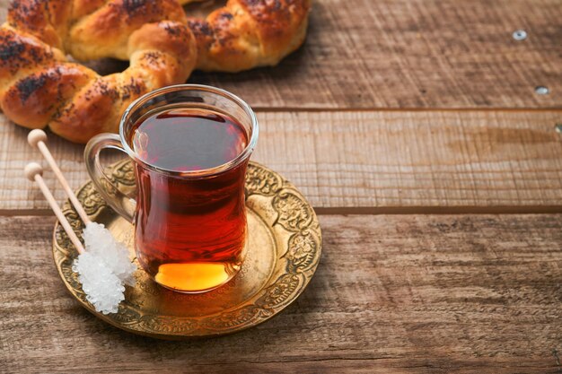 Tè nero turco Tazza di vetro di tè nero turco e bagel tradizionale turco croccante su sfondo vecchio rustico Concetto di pasticceria per la colazione Bevanda calda tradizionale turca