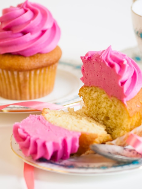 Tè pomeridiano servito con un cupcake rosa.