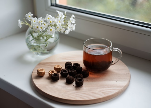 Tè puer cinese in tazza sulla finestra, puerh pressato cinese tradizionale