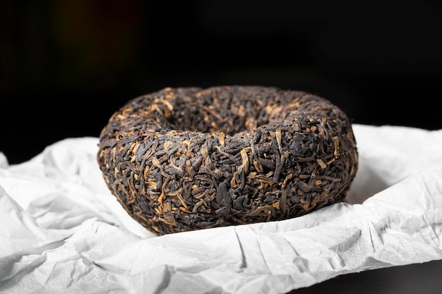 Tè puerh pressato asiatico su sfondo di carta bianca