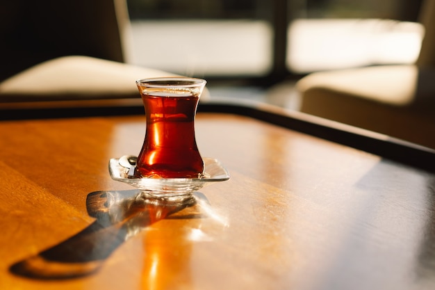 Tè turco servito in un bicchiere a forma di tulipano su un tavolo rustico tè turco in una tradizionale tazza di vetro