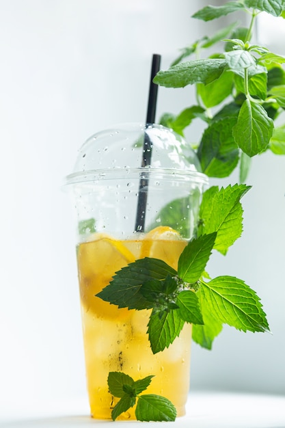 Tè verde al limone e ghiaccio in un bicchiere di plastica