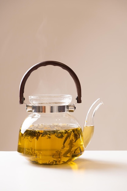 Tè verde cinese con scorza d'arancia in una teiera di vetro