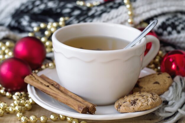 Tè verde con biscotti al cioccolato e bastoncini di cannella, decorazioni natalizie