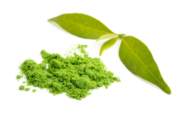 Tè verde in polvere con foglia su sfondo bianco.