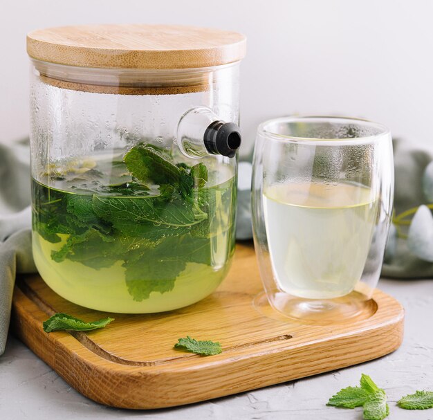 Tè verde in una caraffa e una tazza con la menta