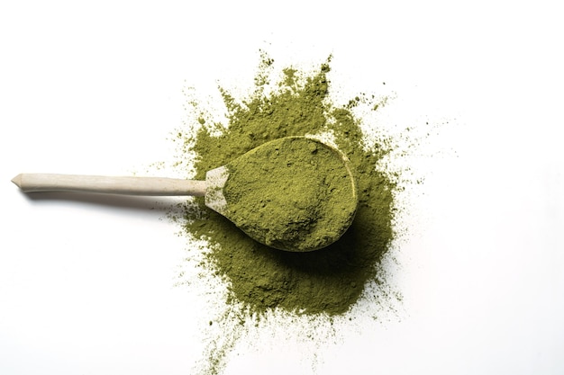 Tè verde Matcha in polvere in un cucchiaio di legno isolato