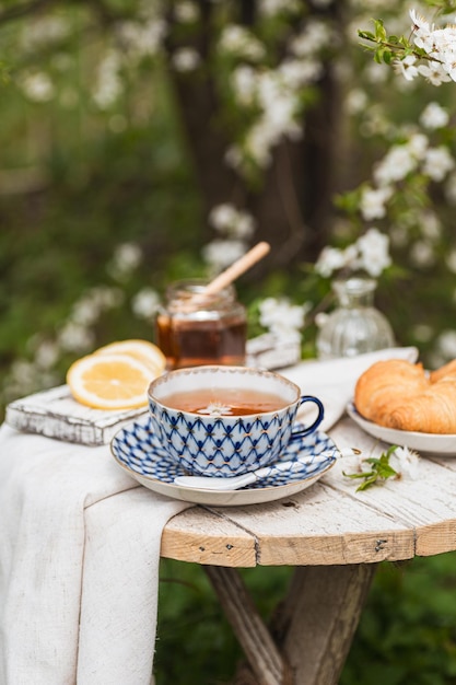 Tea party pomeridiano nel giardino in fiore Verticale