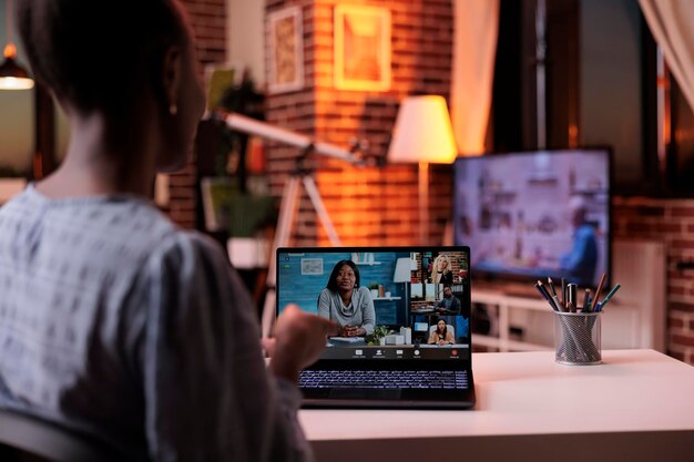 Team aziendale a distanza di brainstorming su riunioni di lavoro online, telecomunicazioni e concetto di telelavoro. Imprenditrice in chat con i colleghi in videoconferenza utilizzando laptop, vista posteriore