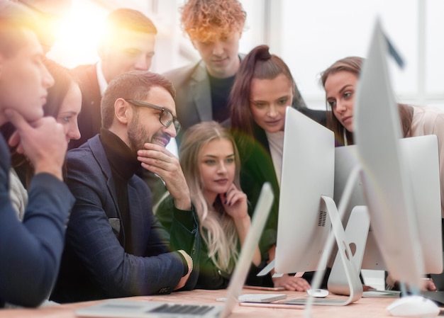 team di giovani dipendenti che guardano insieme lo schermo di un computer. concetto di successo