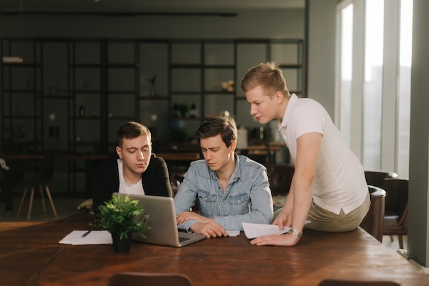 Team di marketing di giovani uomini d'affari che discutono insieme al tavolo del progetto