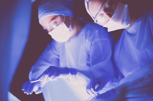 Team di medici in chirurgia in uno sfondo scuro