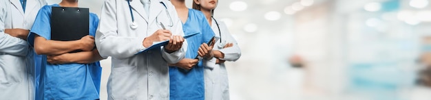 Team di personale medico fiducioso con medico infermiere e professioni specialistiche sanitarie persone sullo sfondo sfocato del corridoio ospedaliero Comunità medica e sanitaria in banner panoramico Neoterico