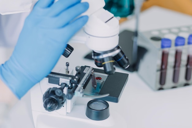 Team di scienziati di ricerca biochimica che lavora con il microscopio per lo sviluppo del vaccino contro il coronavirus nel focus selettivo del laboratorio di ricerca farmaceutica