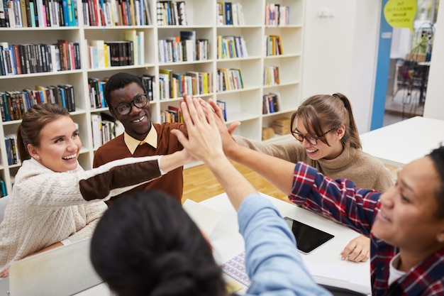 Team di studenti che salutano in biblioteca