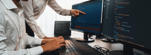 Team di sviluppo software che lavorano insieme in un script di codifica d'ufficio visualizzato sul monitor del computer Programmatore e ingegnere del software che lavora nella società di sviluppo tecnologico Trailblazing