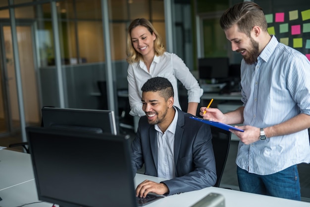 Team di uomini d'affari che lavorano insieme su un computer.