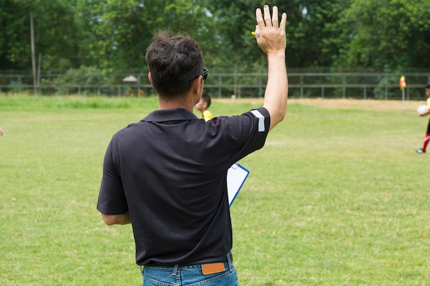 Team Manager Coaching his Crew accanto a calcio o campo di calcio