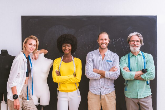 Team multietnico di stilisti al lavoro in un laboratorio di start-up di abbigliamento - Gruppo multietnico di stilisti, stilisti e sarti al lavoro su una nuova collezione