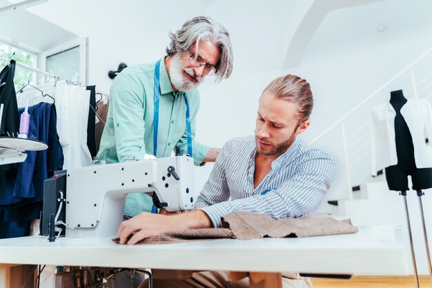 Team multietnico di stilisti al lavoro in un laboratorio di start-up di abbigliamento - Gruppo multietnico di stilisti, stilisti e sarti al lavoro su una nuova collezione