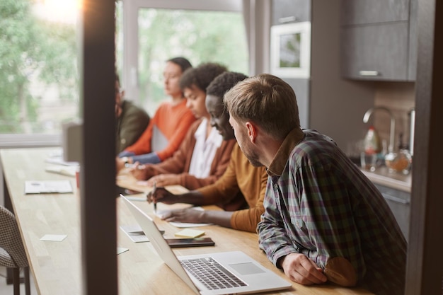 Team multinazionale seduto a un tavolo in un coworking ce