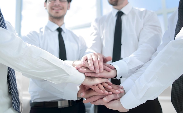 Team professionale di affari che piegano le mani insieme al concetto di lavoro di squadra