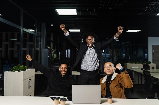Teambuilding neri africani e asiatici colleghi positivi di razza mista sorridono gioire del successo del lavoro di squadra su un progetto congiunto