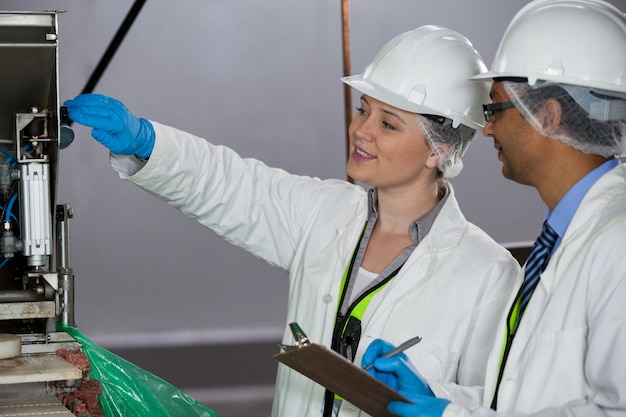 Tecnici che esaminano la macchina per la lavorazione della carne