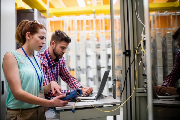 Tecnici che utilizzano computer portatile mentre analizzano il server