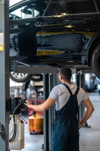 Tecnico automobilistico che prepara l'automobile del cliente per l'ispezione visiva