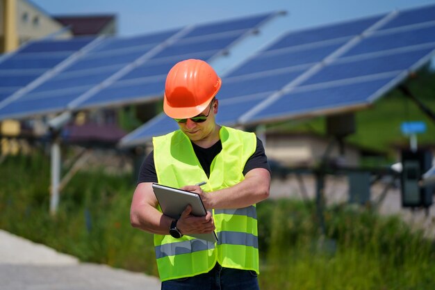 Tecnico che controlla l'efficienza del pannello solare nella centrale solare