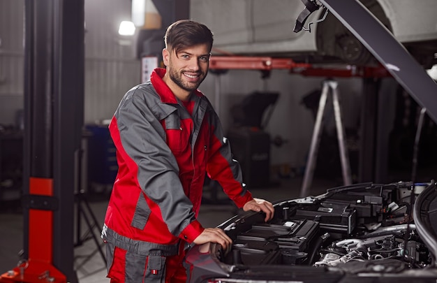 Tecnico che esamina il motore dell'auto in officina