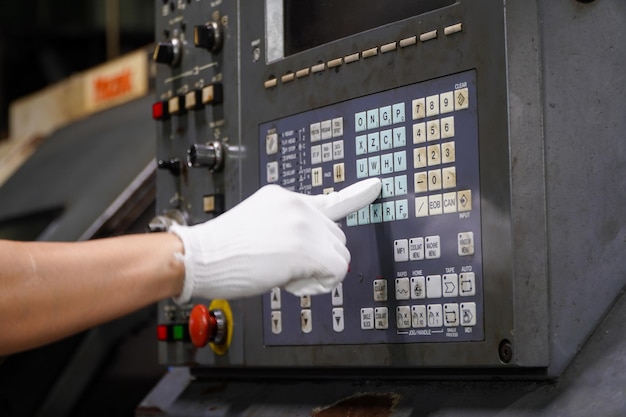 Tecnico che regola il programma di una macchina cnc Processi di formatura plastica e metallo in impianti industriali