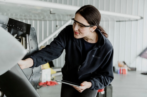 Tecnico dell'aviazione femminile che ripara il motore di un aereo a elica