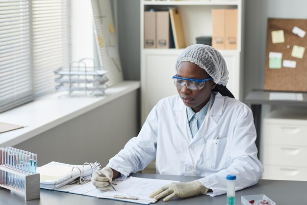 Tecnico di laboratorio che scrive nel documento