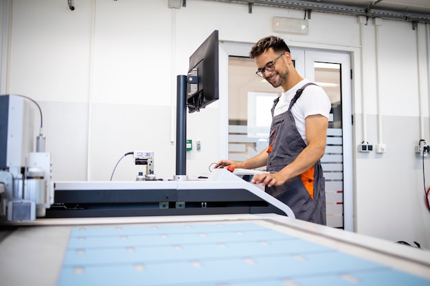 Tecnico esperto che opera macchina industriale CNC in fabbrica.