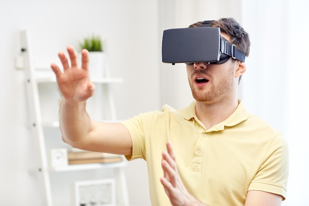 Tecnologia 3d, realtà virtuale, giochi, intrattenimento e concetto di persone - giovane stupito con cuffie per realtà virtuale o occhiali 3d che giocano