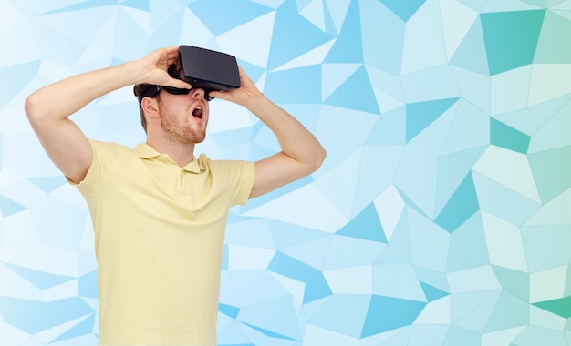 Tecnologia 3d, realtà virtuale, intrattenimento e concetto di persone - giovane stupito con cuffie per realtà virtuale o occhiali 3d che giocano su sfondo blu texture low poly,